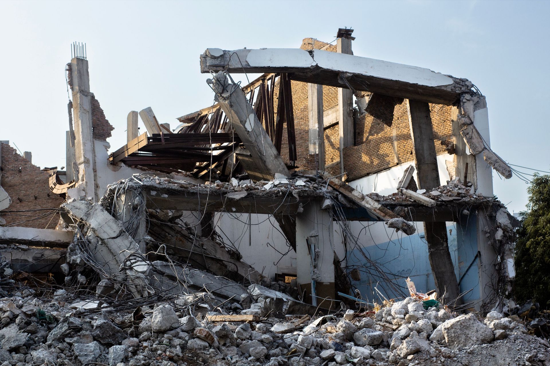A partially demolished building showcasing exposed beams and rubble at an urban site.